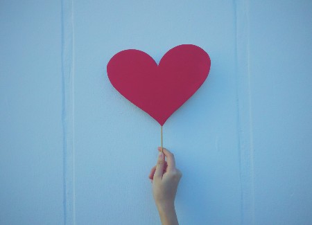 Image of person holding a red paper heart